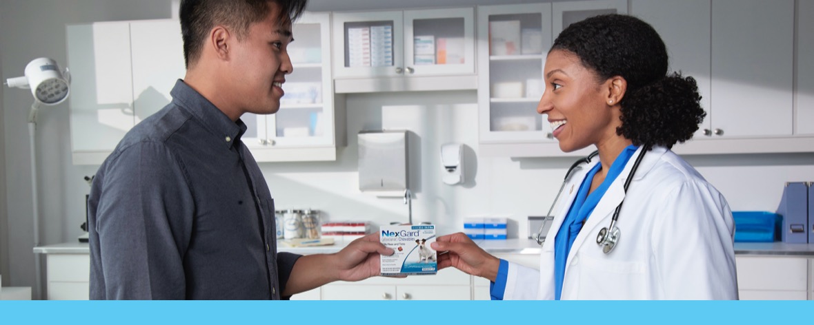 Vet giving a nexgard package to a customer 