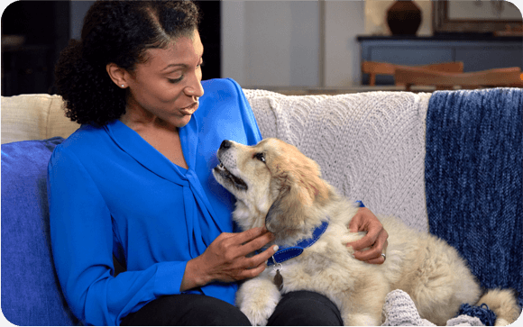 A woman pets her happy dog